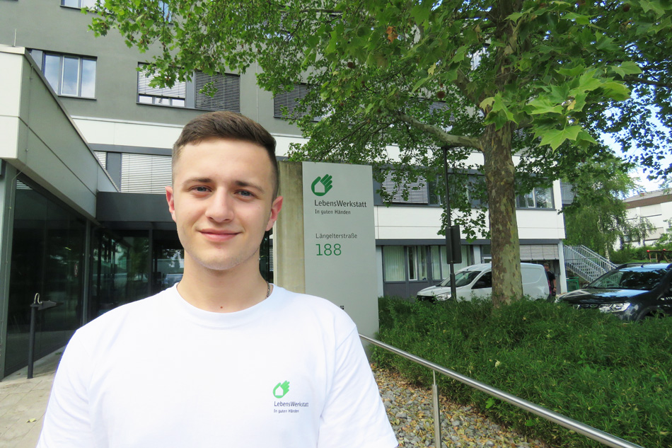 Azubi Felix vor dem Gebäude der LebensWerkstatt