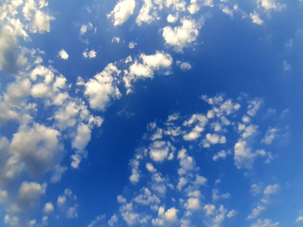 Blauer Himmel mit verstreuten weißen Wolken.