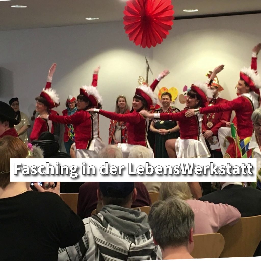 Tanzgruppe in roten Kostümen feiert Fasching vor Publikum in der LebensWerkstatt. Fröhliche Karnevalsstimmung.