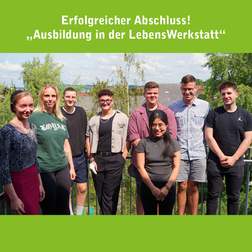Gruppe junger Leute feiert erfolgreichen Ausbildungsabschluss in der LebensWerkstatt bei sonnigem Wetter auf einer Terrasse.