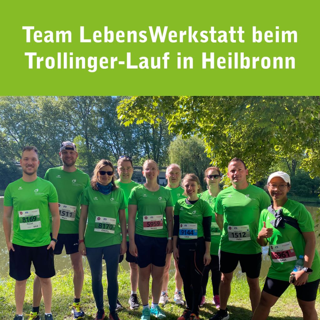 Gruppe von zehn Läuferinnen und Läufern des Teams „LebensWerkstatt“ beim Trollinger-Lauf in Heilbronn. Alle tragen grüne Laufshirts mit dem Logo der LebensWerkstatt und stehen bei sonnigem Wetter im Grünen vor einem Fluss. Oben im Bild steht der Text: „Team LebensWerkstatt beim Trollinger-Lauf in Heilbronn“.