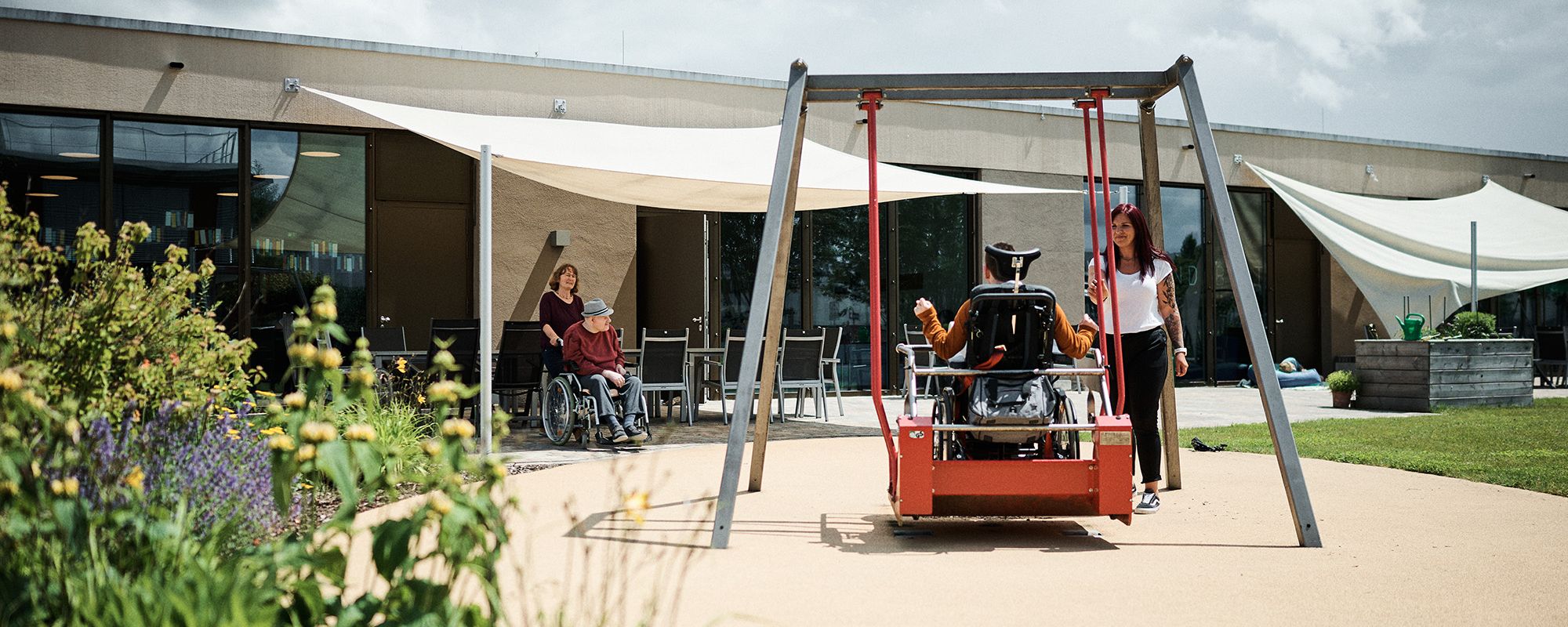 Eine Rollstuhlschaukel im Außenbereich der LebensWerkstatt wird gerne genutzt