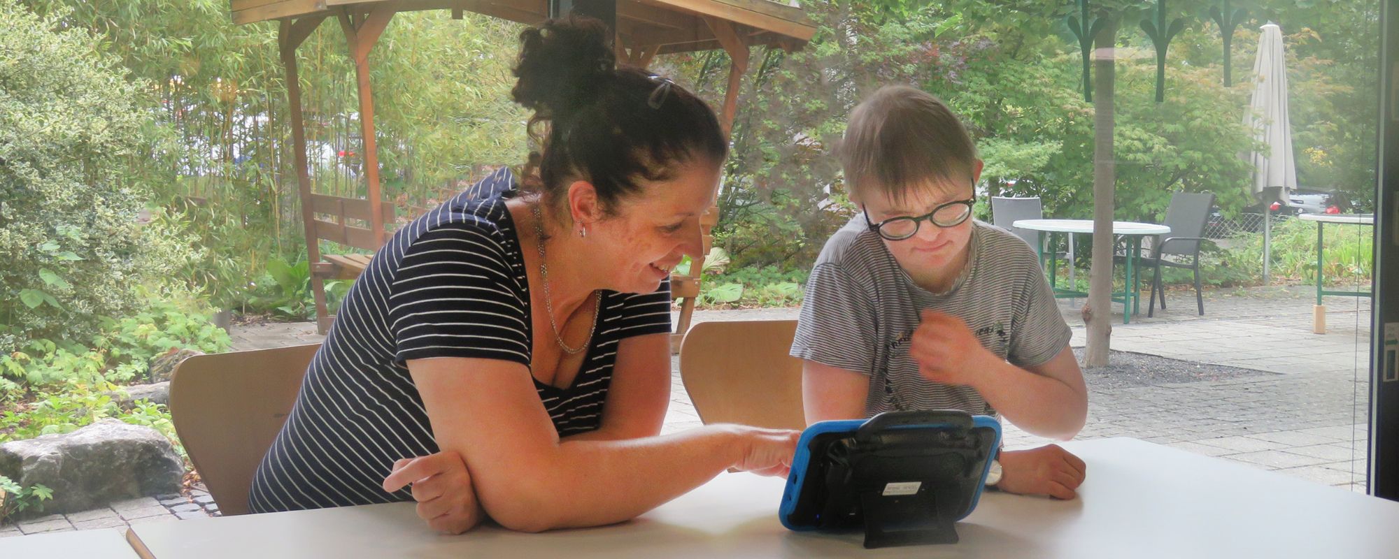 eine frau lernt mit einem jungen menschen mit hilfe eines lerncomputers