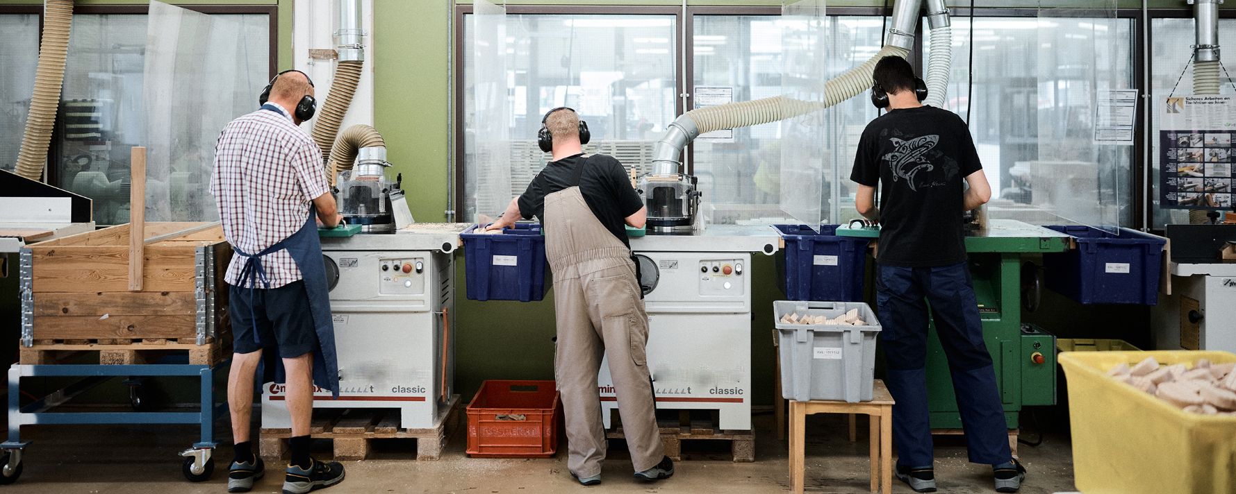 drei menschen arbeiten in einer modernen werkstatt