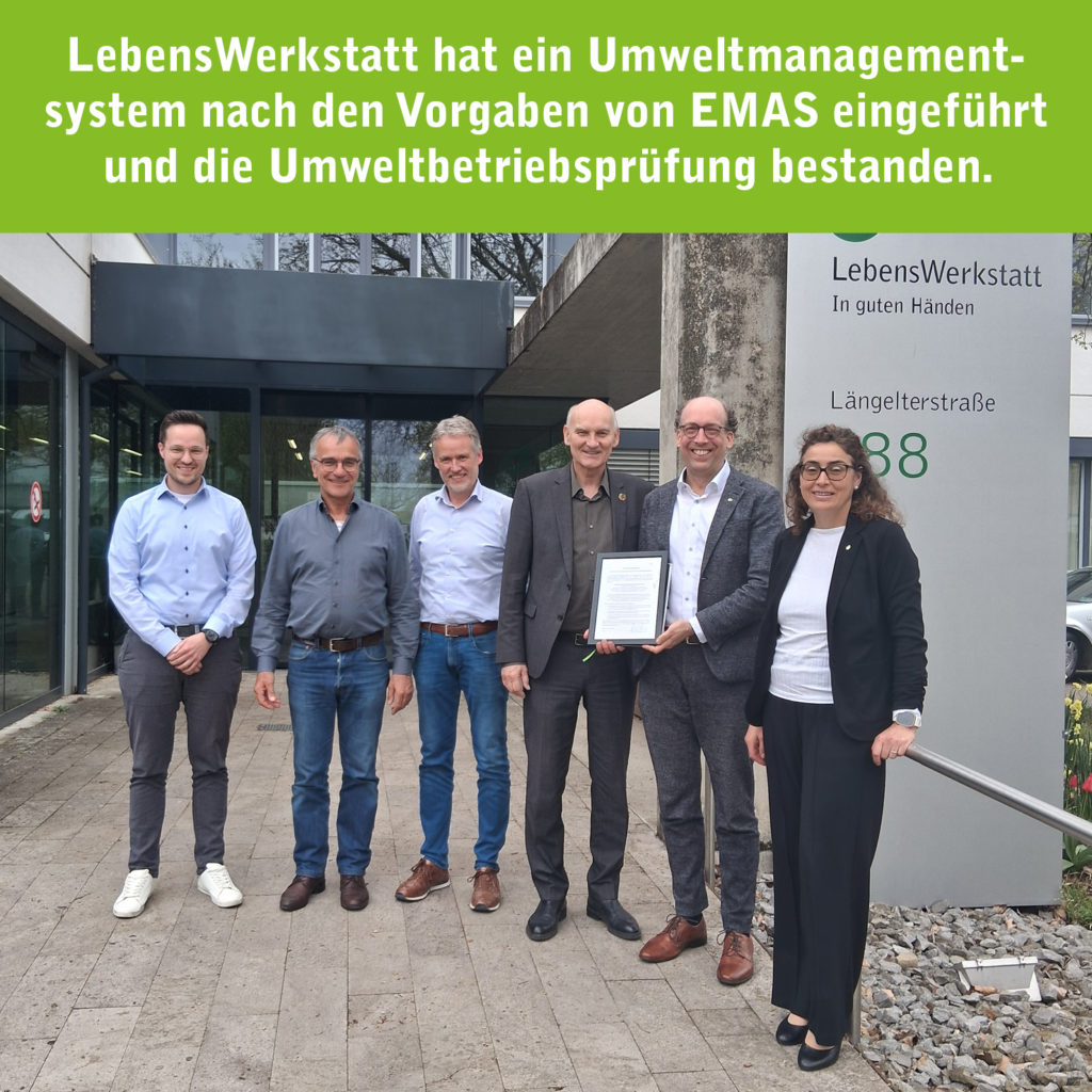 Gruppenfoto vor der LebensWerkstatt: Feierliche Übergabe des EMAS-Zertifikats für das Umweltmanagementsystem.