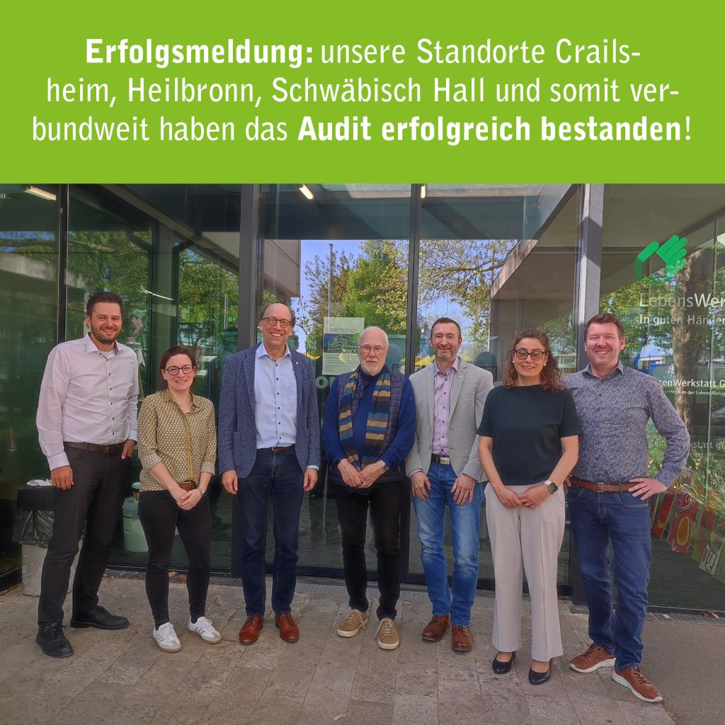 Gruppenfoto von Mitarbeitern vor einem Gebäude. Sie feiern den erfolgreichen Abschluss eines Audits.