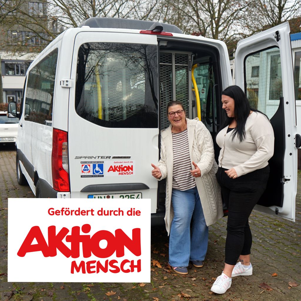 Zwei Frauen stehen neben einem weißen Sprinter, der von Aktion Mensch gefördert wird. Beide lächeln und zeigen Daumen hoch.