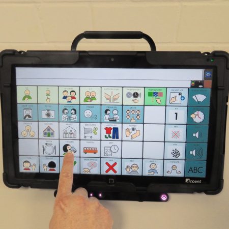 Person nutzt Kommunikationsgerät mit Symbolen für Sprache und Aktionen.